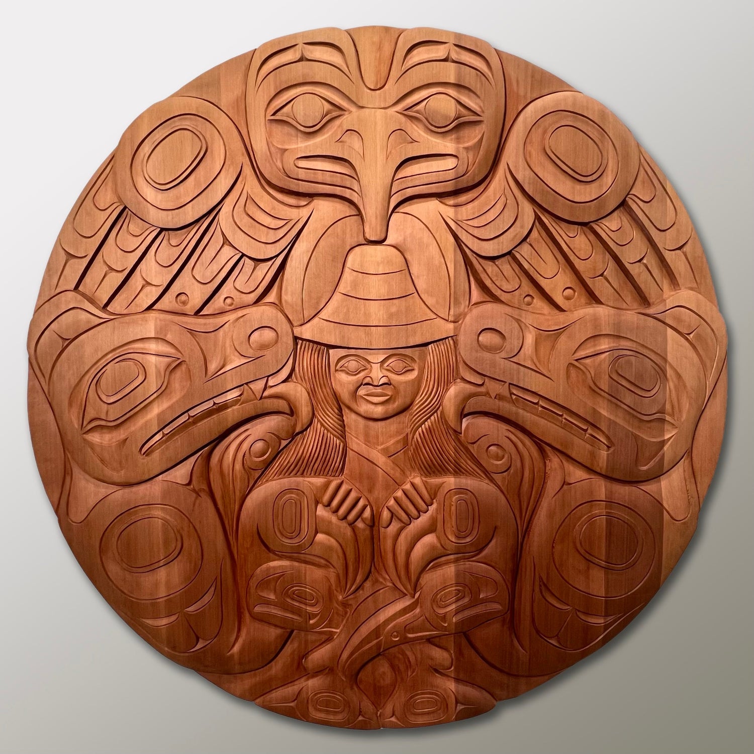 Eagle, two bears, two salmon, & a woman in the center.